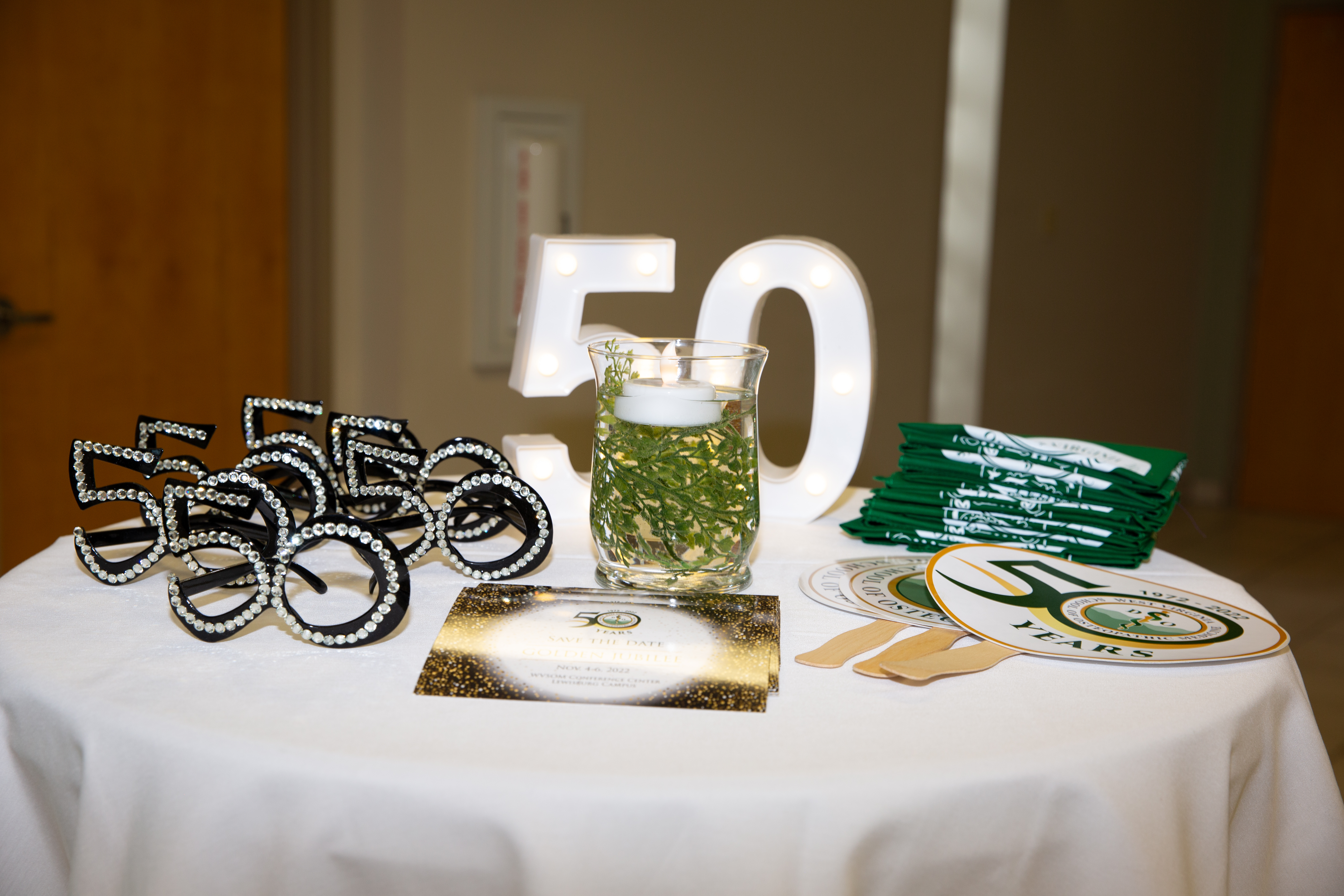 50th event swag table, glasses, fans, brochures 