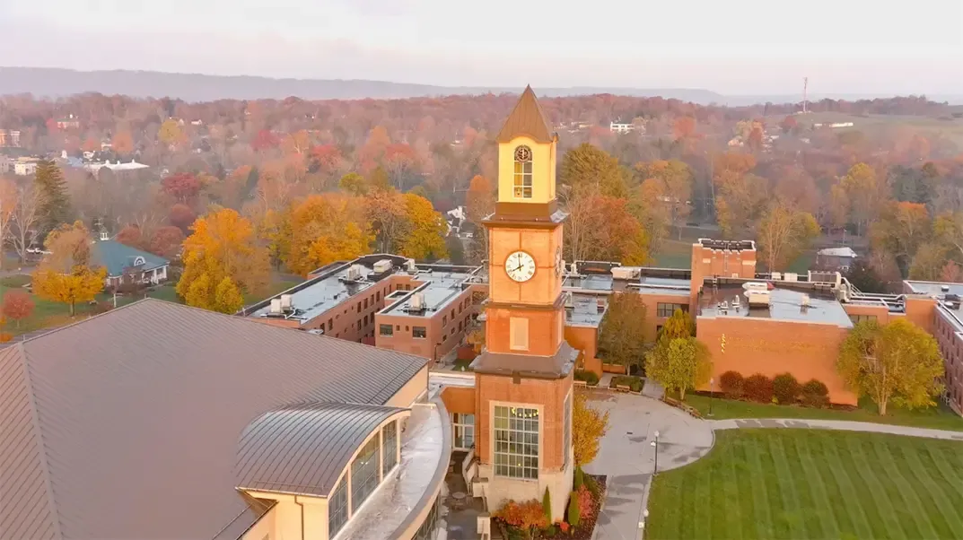 Aerial view of clock tower with fall foliage and distant mountains visible in background