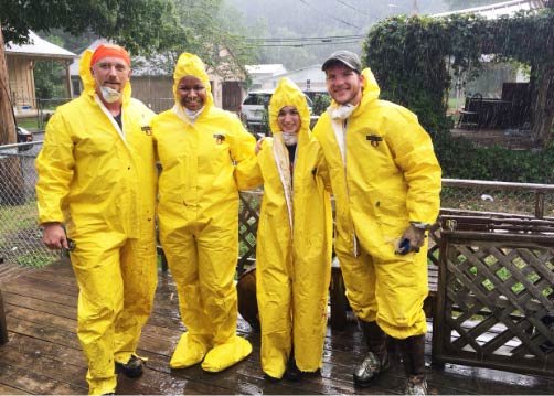 Students in full rain protective gear helping clean up flood damage