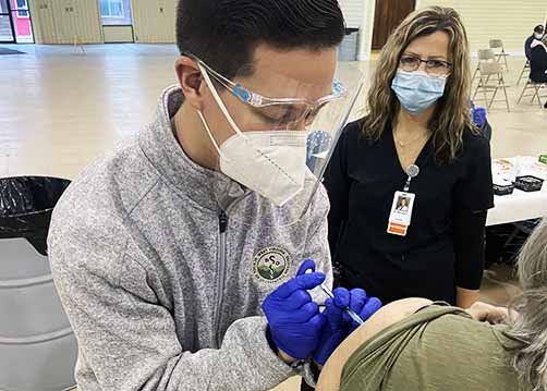 WVSOM Students gives a community member a covid-19 vaccine