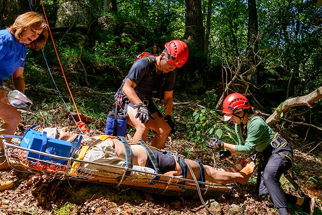 People placing ropes around a rescue device during a wilderness medicine scenario