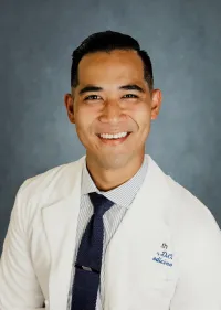 Miles Medina, D.O. portrait wearing white coat and tie.